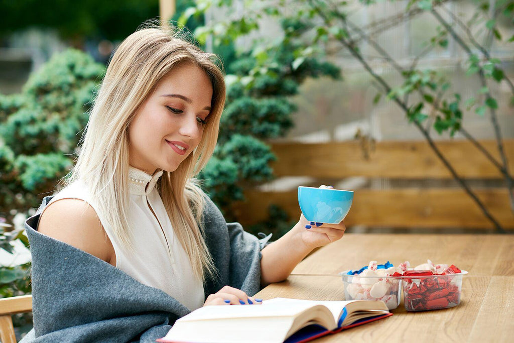 She has coffee. Девушка красивая в кафе на свежем воздухе. Девушка читает книгу и пьет кофе. Фотосессия девушка читает книгу и пьёт кофе. Девушка в кафе пьет кофе и читает книгу.