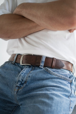 A man sitting in a leather belt. Сlose-up