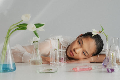 Asian woman using Jumping Java plant-based skincare products on a white table