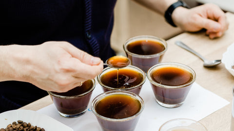 Man tasting different types of freshly brewed coffee at a table