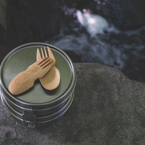 Two bamboo sporks sitting in a green surface