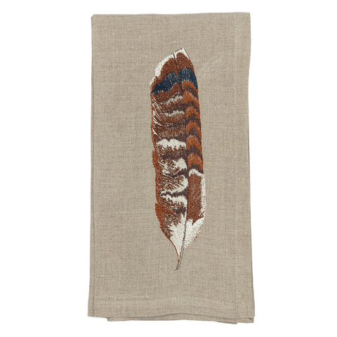 Red tail feather on a cloth napkin