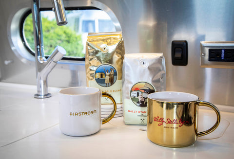 Two bags of coffee and two coffee mugs sitting on the countertop in an Airstream.