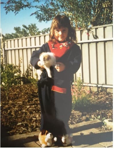 Young girl holding a puppy from the 1990's