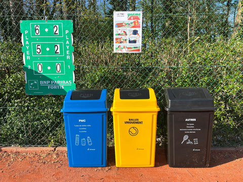 3 poubelles de tri sur un terrain de tennis