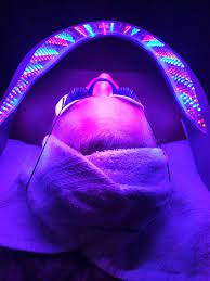 Images of a client receiving a Celluma LED facial treatment.