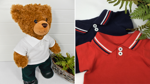 Photo on the left shows a Build a Bear teddy bear wearing a white polo t-shirt, black pants and black shoes. The teddy bear is standing in front of a white background with a green fern plant to the right. The photo on the right shows 2 teddy bear t-shirts lying on a white surface with a green fern in the top right hand corner. The teddy bear polo t-shirt on the top is red with white buttons and a red and blue trim on the collar. The teddy bear polo shirt on the bottom is navy blue with white buttons and a red and white trim on the collar.