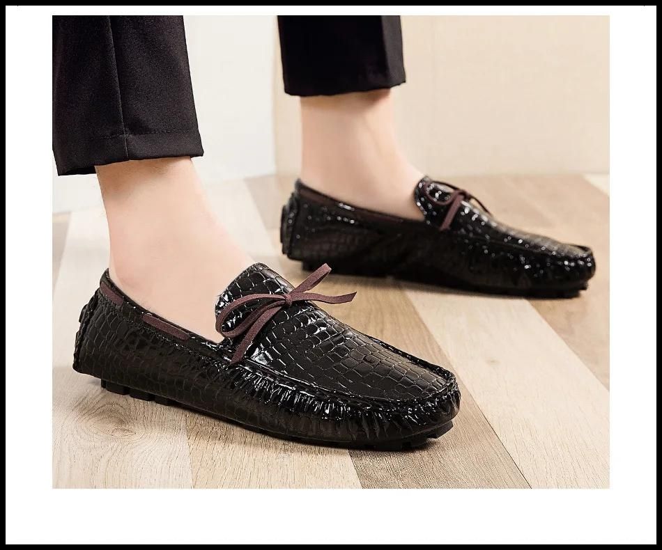 Men’s casual loafers’ shoes in black, with textured pattern and brown laces, worn with dark trousers