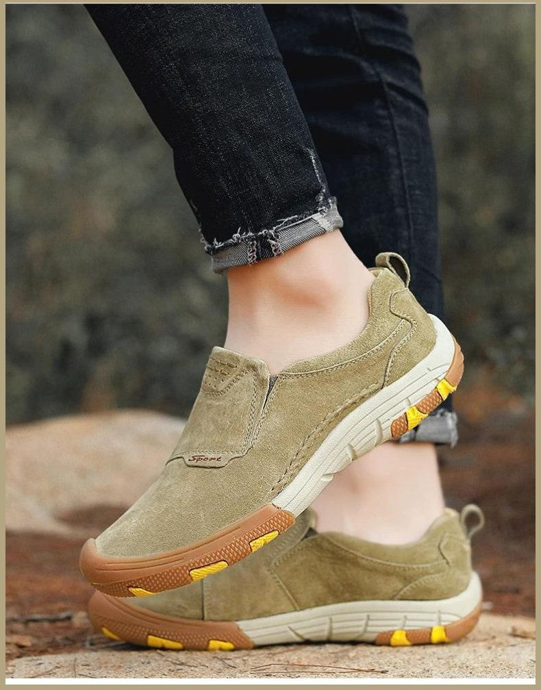 Olive green men’s slip-on sneakers with white soles, paired with frayed black jeans for a casual look.