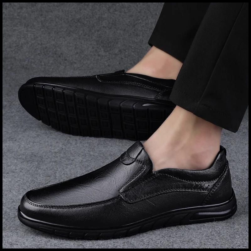 Man in Men’s walking loafers, black leather shoes, on a grey surface