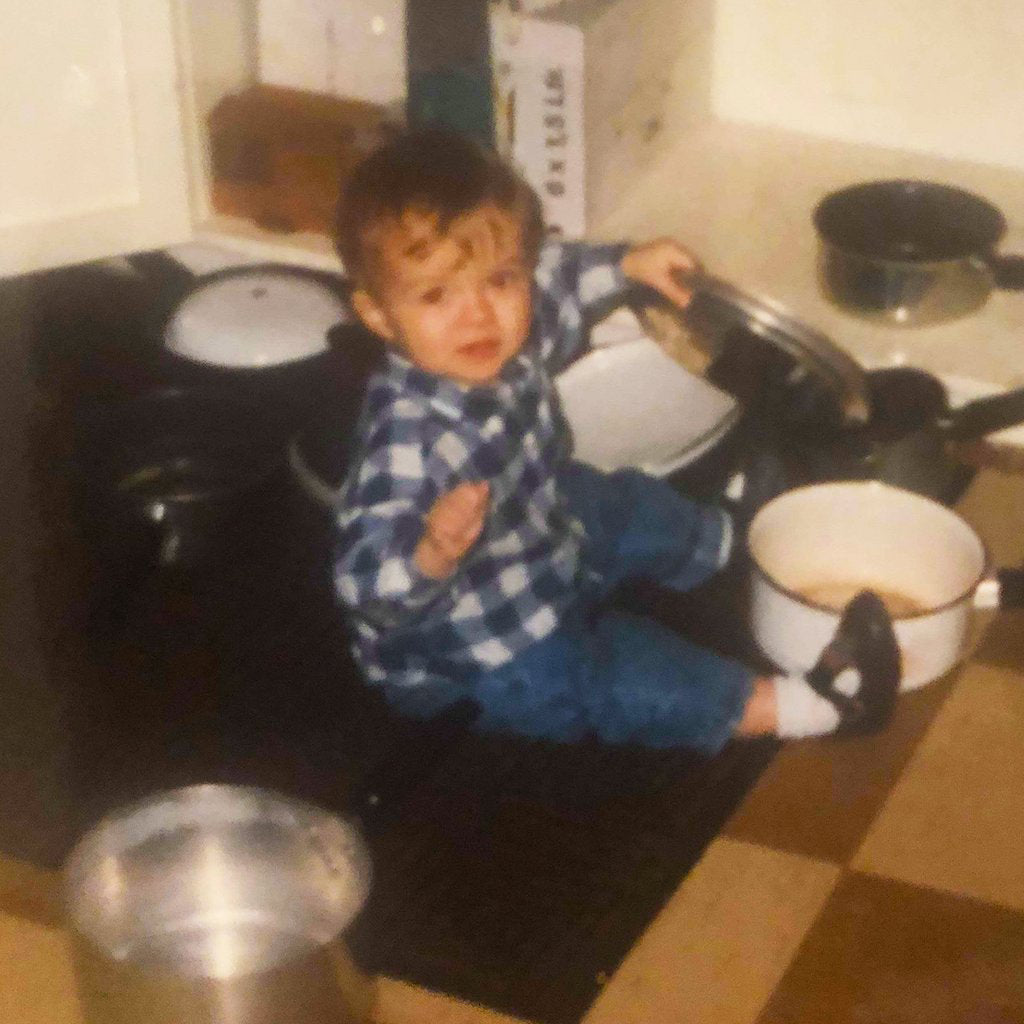 Jack, aged 2, sitting on the kitchen floor playing with pots and pans