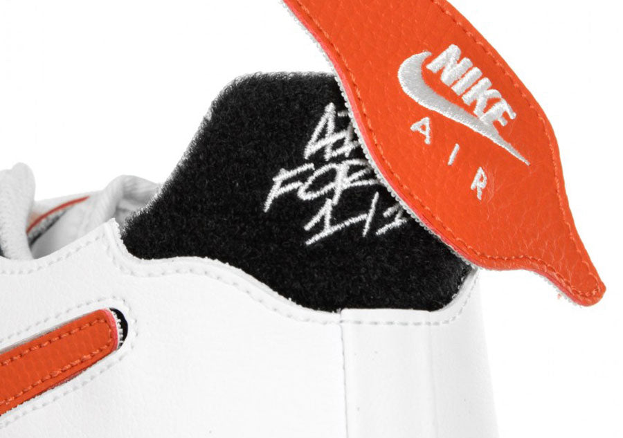 Dettaglio del tallone della sneaker bassa con tomaia customizzabile con sistema di pannelli in velcro Nike Air Force One of One nella doppia colorazione white orange a base nera