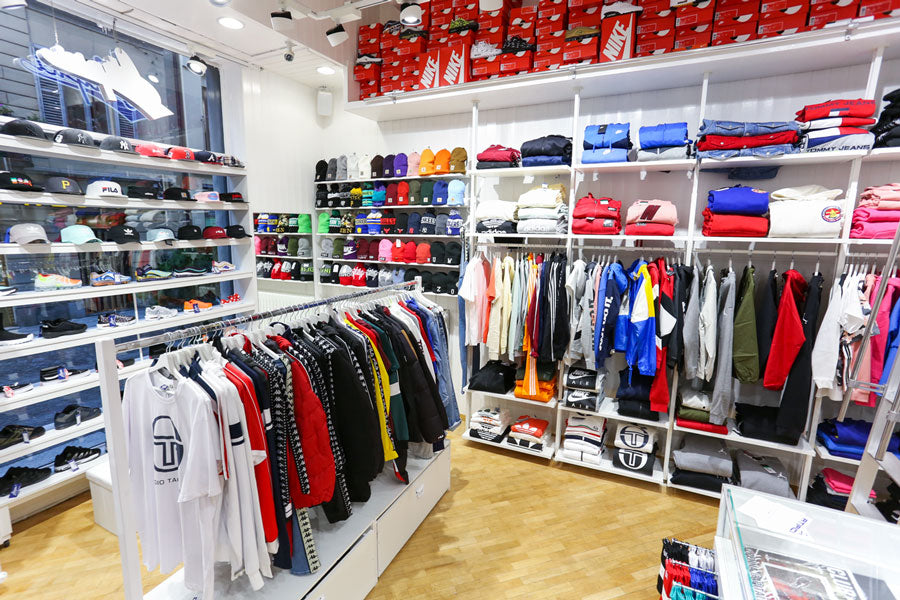 Interno del negozio di Atipici Shop Novara con abbigliamento streetwear e cappellini a visiera piatta stile urban esposti