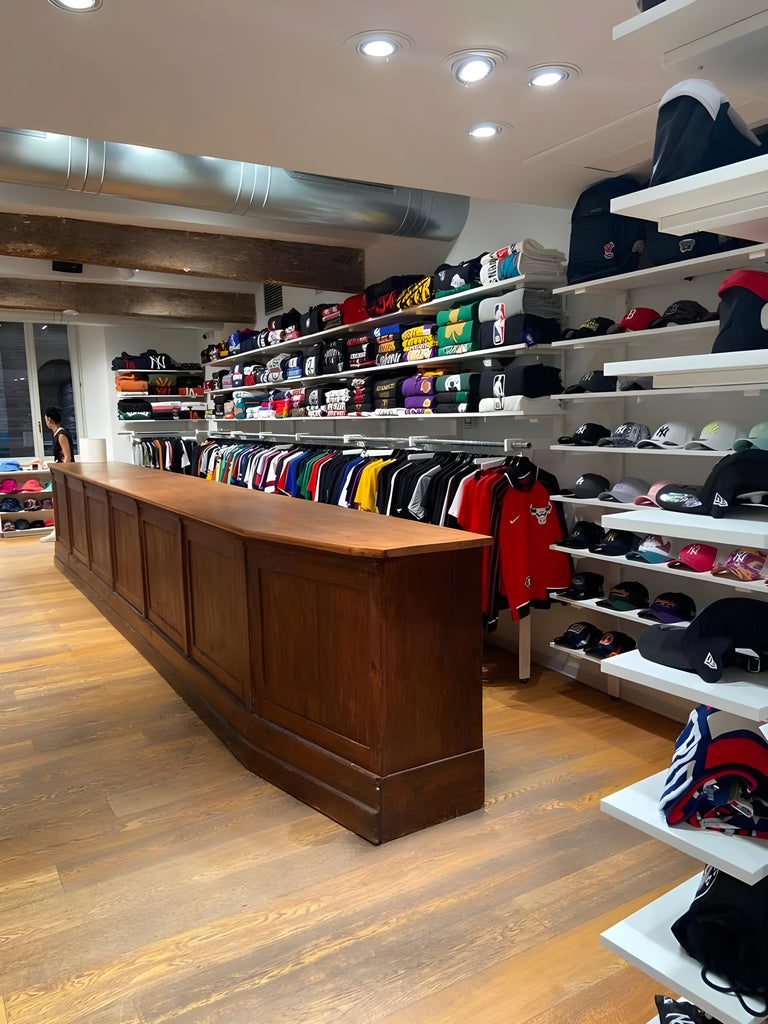 Selection of clothing, caps with visors and fan gear accessories from the best NBA, NFL, MLB and NHL teams positioned inside The Playoffs Corner, the space dedicated to US Sports fan gear in the Atipici Shop Bologna store in via Clavature 14