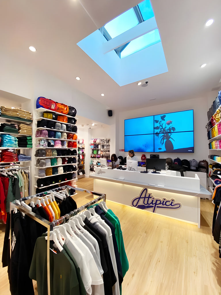 Selection of products on shelves and displays inside the ATIPICI Shop Milano streetwear store in Corso Buenos Aires 25