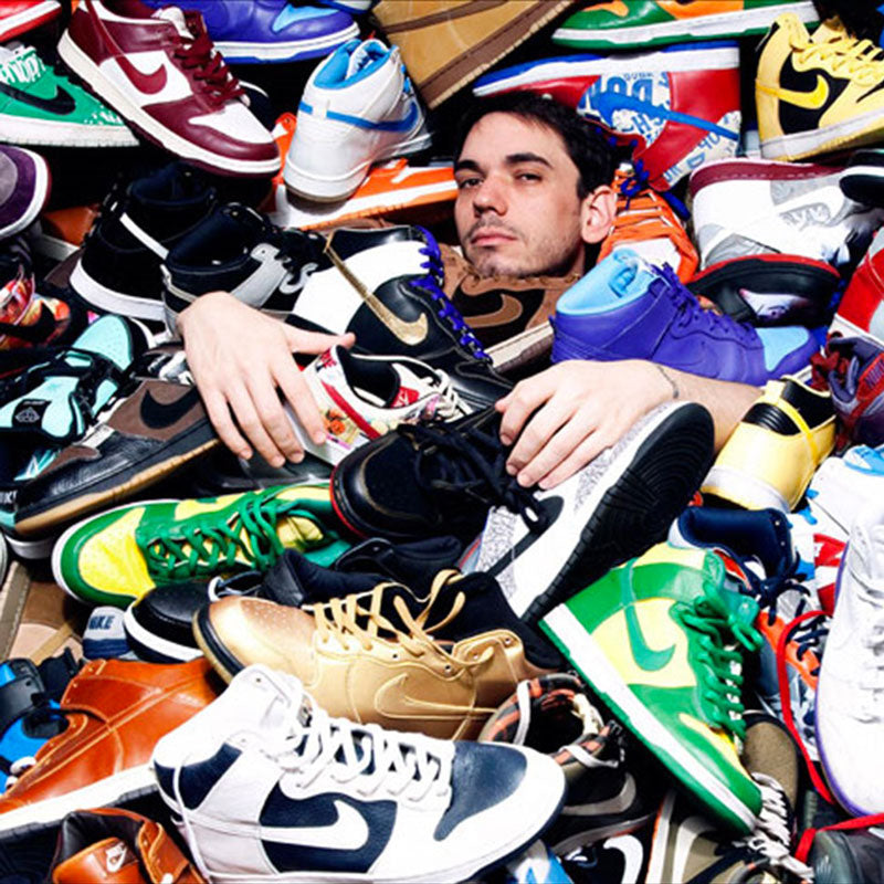 Boy proud of being submerged by an avalanche of Nike and Jordan sneakers including Nike Dunk, Air Jordan and other iconic pairs of street culture