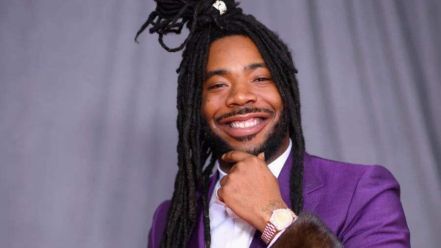 DRAM in purple tuxedo smiles