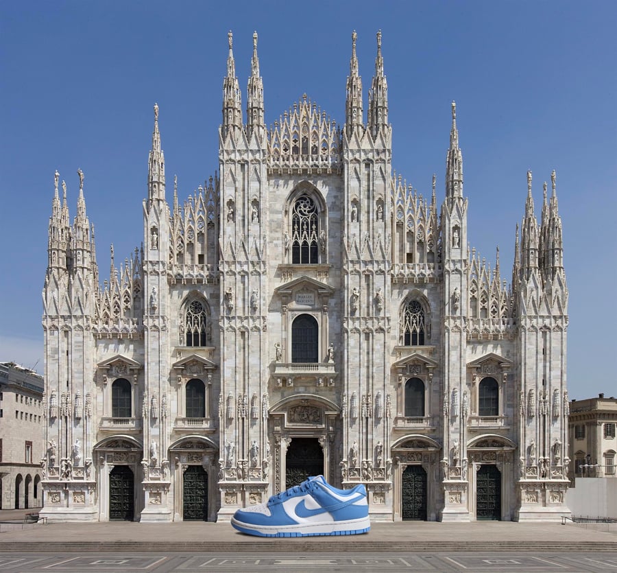 Vista frontale del Duomo di Milano con davanti all'ingresso sneaker gigante Nike Dunk Low UNC nella colorway bianca/azzurra "University Blue" in onore dei colori della University of North Carolina