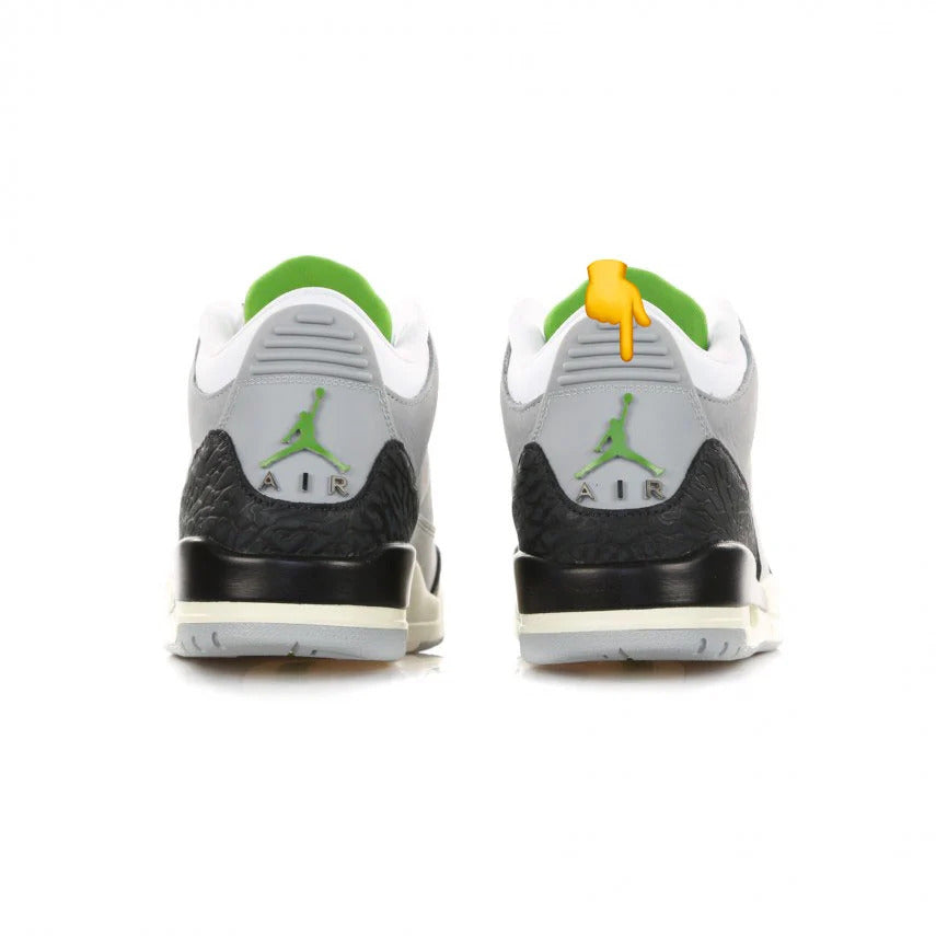 Pair of Air Jordan 3 sneakers, seen from the back with gray plastic hell tab marked with a green Jumpman logo overlay