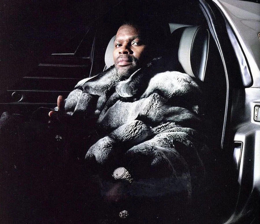 J-Pierce with gray fur in a car during a music video