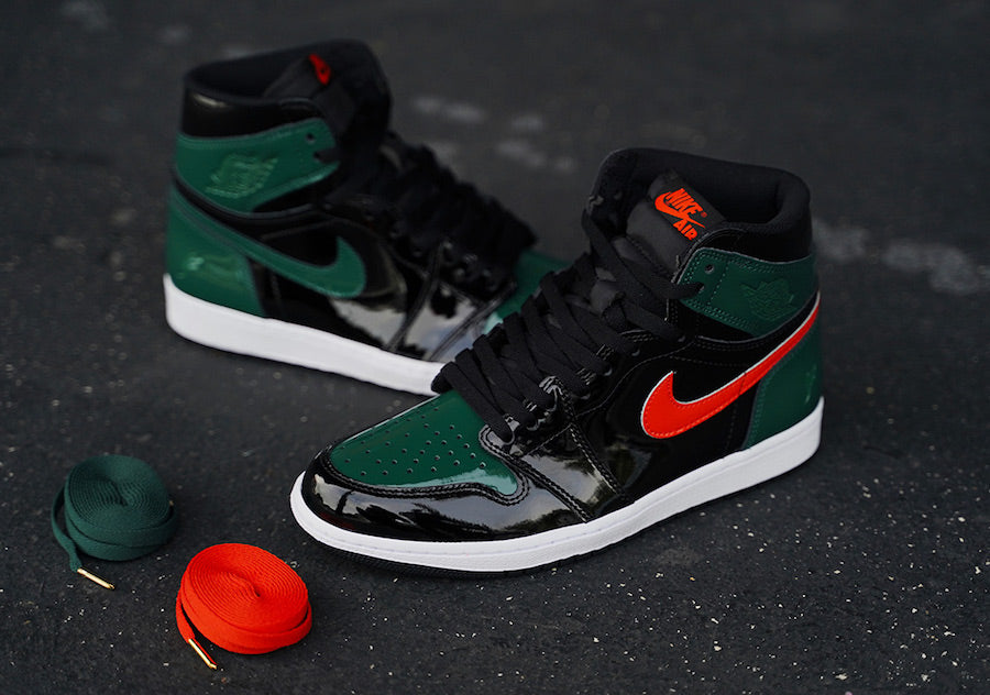 Pair of shoes, Air Jordan 1 High x Solefly, black and dark green painted colorway with external red lateral swoosh