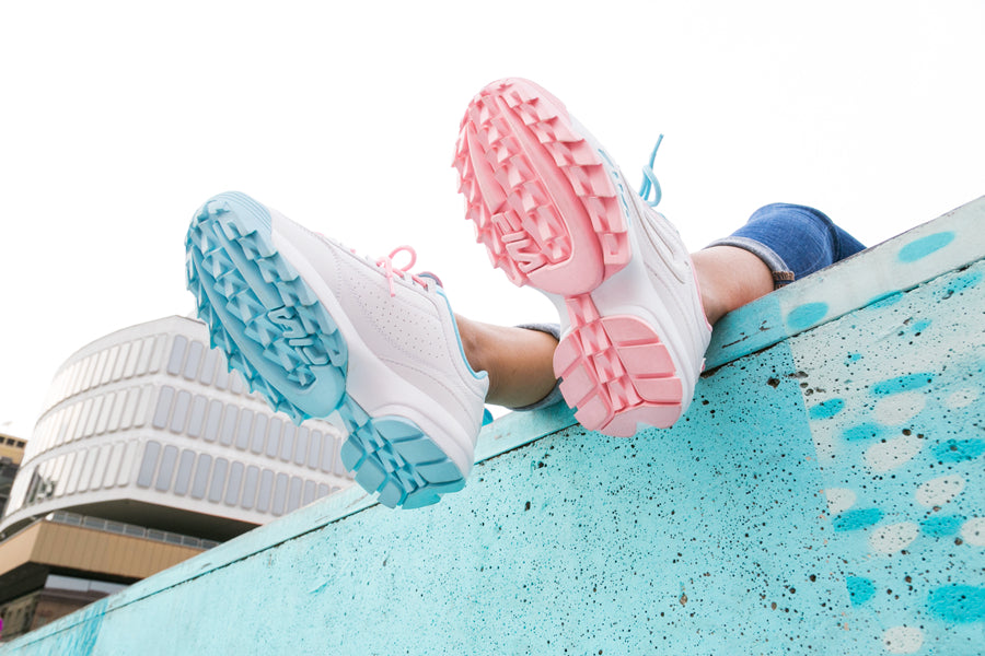 Sole of the Fila x Atipici Disruptor sneakers in The Candy Shop color with the outer sole coloring in pastel baby blue for the left shoe and pastel baby pink for the right shoe