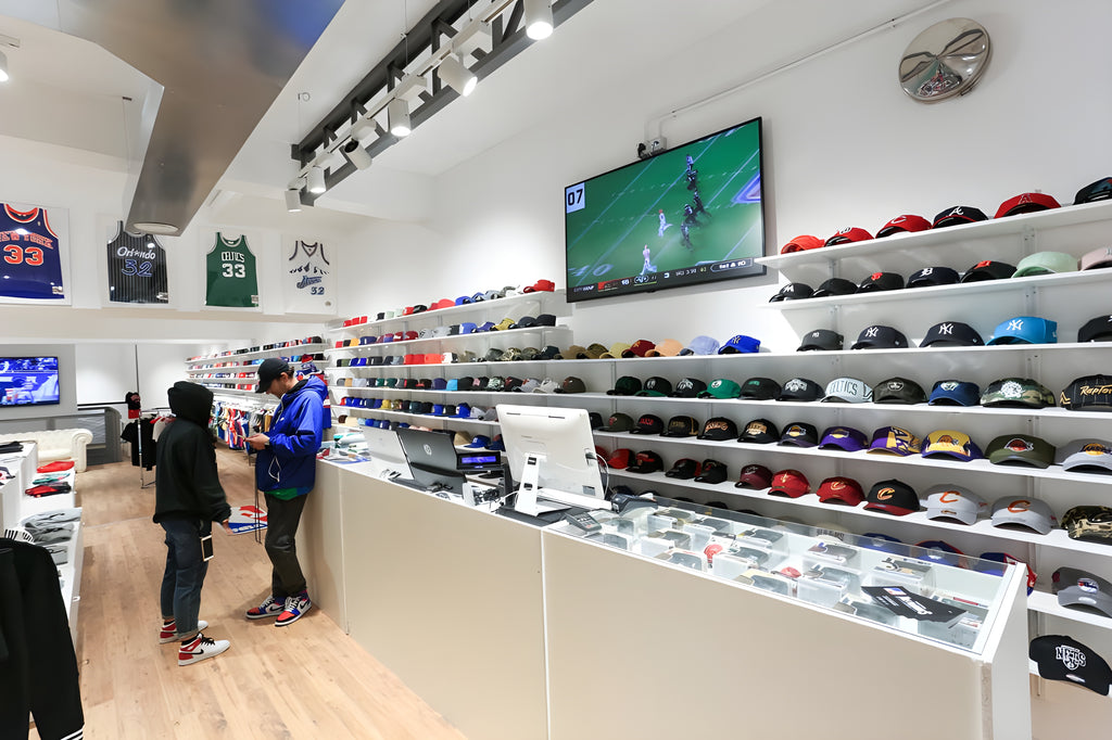 Interior of the NBA, NFL, MLB and NHL clothing, caps, shoes and other sporting goods shop of The Playoffs Torino in Via Roma 220 with television broadcasting match highlights