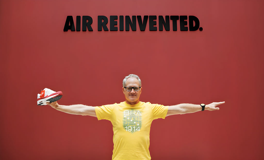 Tinker Hatfield with open arms holding her creation: the first Air Max 1 in the white and red color, with "Air Reinvented" written on it