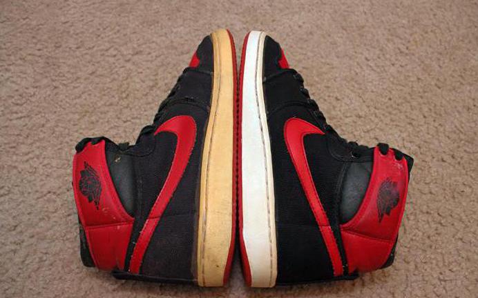 Pair of Air Jordan 1 Mid sneakers of which the left one is Yellowed or shows signs of aging of the once white midsole now yellowed