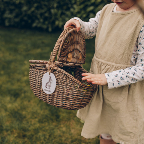 Child holding Easter wicker basket with personalised tag