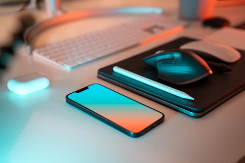 Desk workspace with laptop, smartphone, and wireless mouse. Sustainable organization concept.