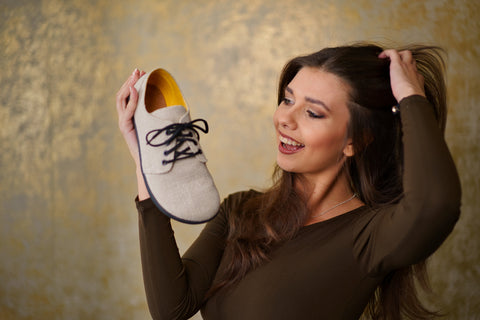 Frau hält Ahinsa Shoes Hanf-Barfuß-Halbschuhe