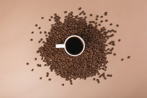 café en taza y granos de café de especialidad al rededor