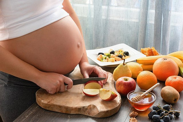 1. pregnant woman preparing fruit salad