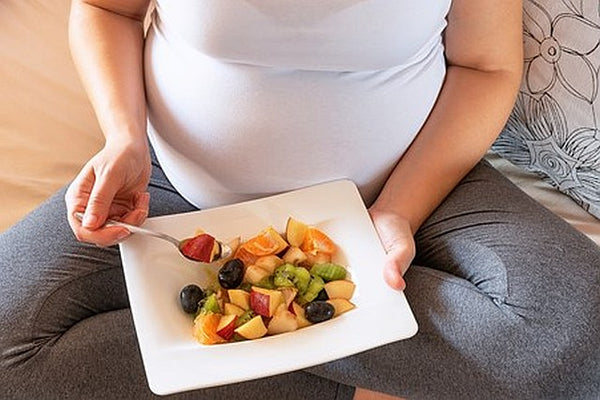 10. Pregnant woman eating a bowl of fruit