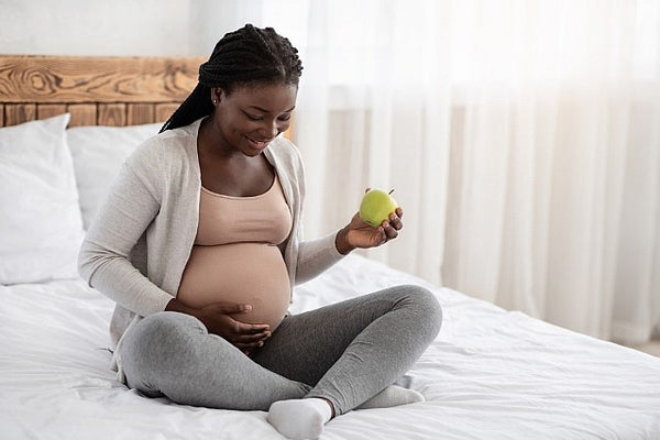 1 Pregnant woman holding a green apple