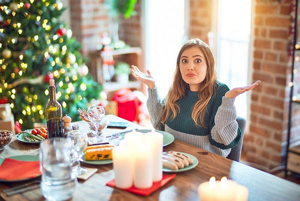 Woman sat at dining table at Christmas wondering what to eat!