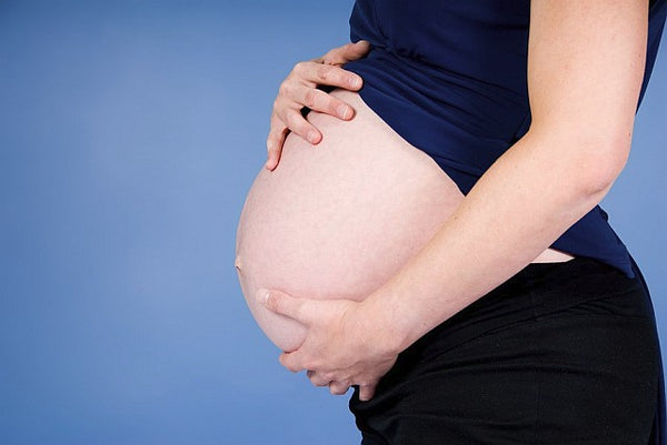 pregnant woman holding exposed bump