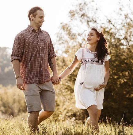 pregnant woman and male partner holding hands, out for a walk