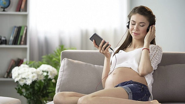 4 pregnant lady listening to calming music on headphones