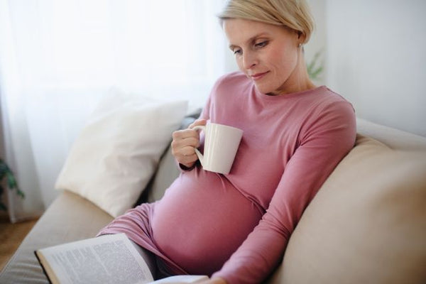 6. Woman with baby bump reading and relaxing