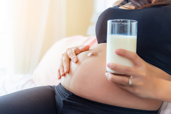 7. Pregnant woman with a glass of milk