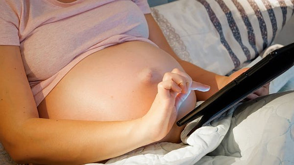 7. pregnant woman using a tablet whilst relaxing