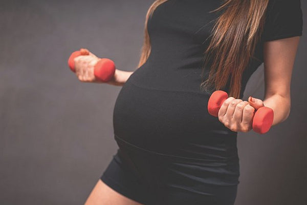 Mum-to-be exercising with small hand held weights