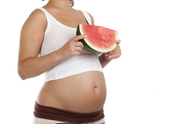 9. pregnant lady holding a large slice of watermelon