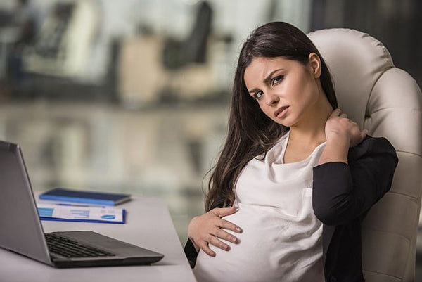 pregnant working woman looking stressed