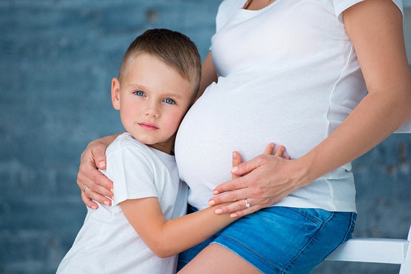 blue eyed boy listening to mummys pregnant tummy