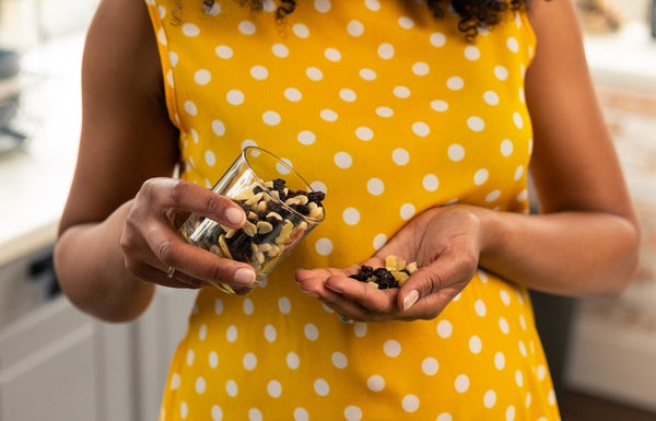 Woman in polkadot dress holding glass of mixed nuts
