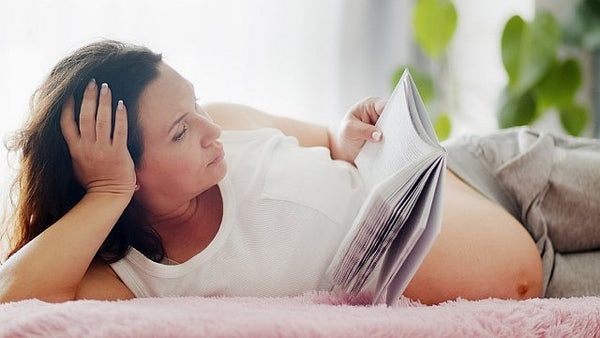 Pregnant mum reading whilst lying down