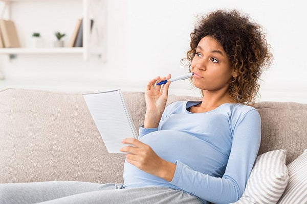 pregnant woman thinking about writing a list